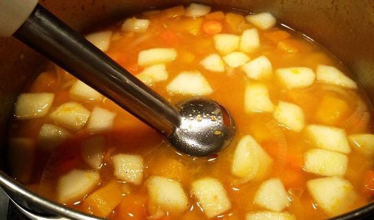 Pureeing butternut squash soup with immersion blender.