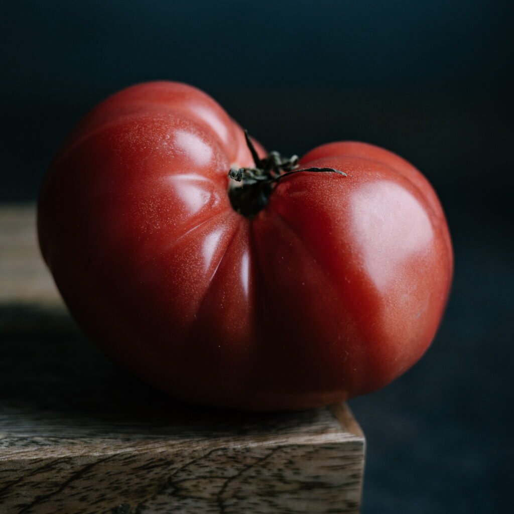 Single heirloom tomato against a dark background