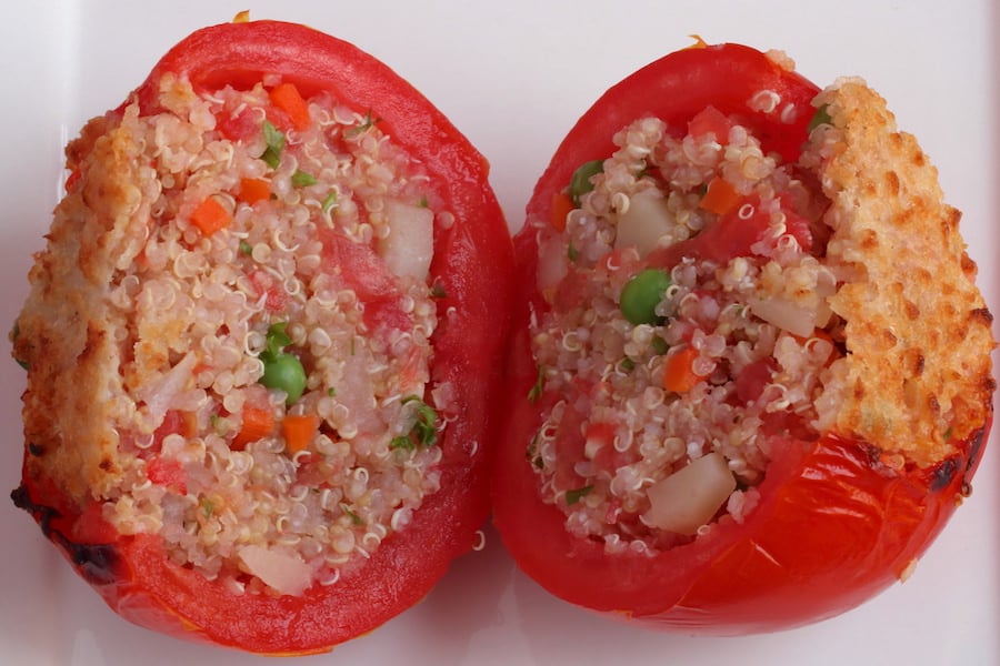 Four Vegan Stuffed Tomatoes with Quinoa on a white platter