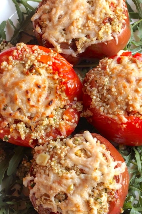 Quinoa Stuffed tomatoes on a bed of arugula