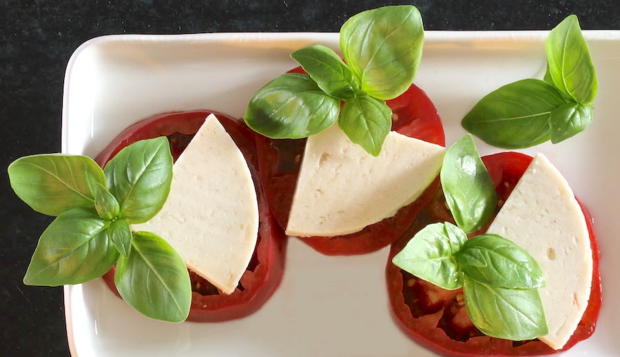Three tomato slabs with cashew cheese and basil
