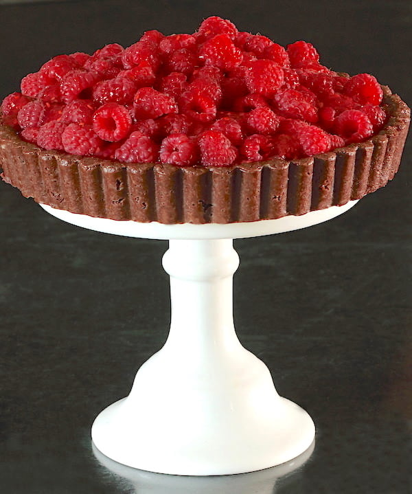 Fresh Raspberry Tart on a white pedestal