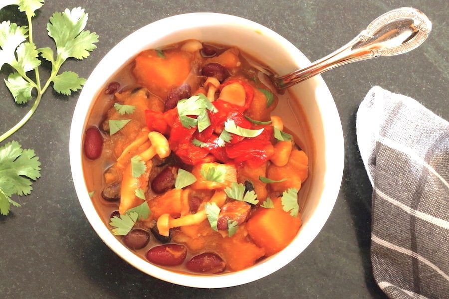 Butternut Squash Chili in a bowl with sprig of cilantro t the side