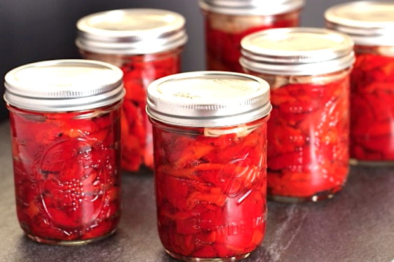 Six pint mason jars filled with roasted red peppers