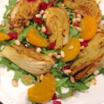 Plate of roasted fennel and citrus salad served on a bed of arugula