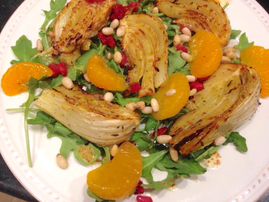 Plate of roasted fennel and citrus salad served on a bed of arugula