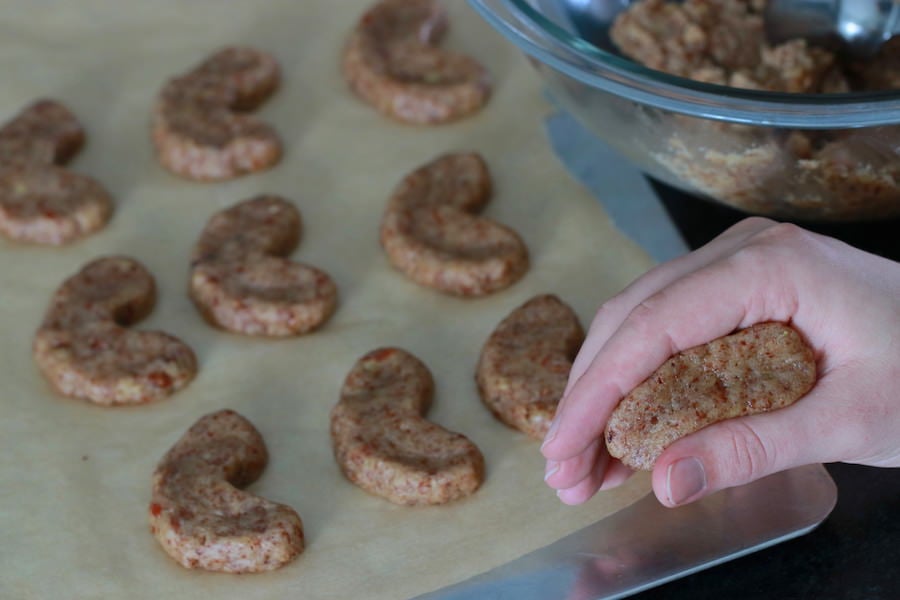 Forming cookie batter into crescent shaped vegan pecan cookies
