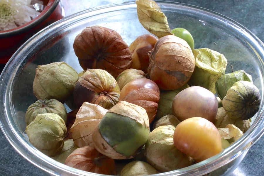 A bowlful of tomatillos still in their husks