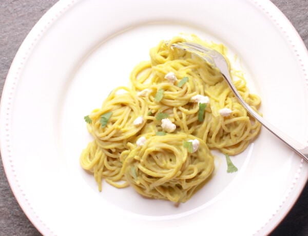 Pasta Poblano served on a large plate garnished with cilantro and bits of cream cheese