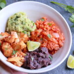 Cauliflower, guacamole, red rice, and black beans in a bowl