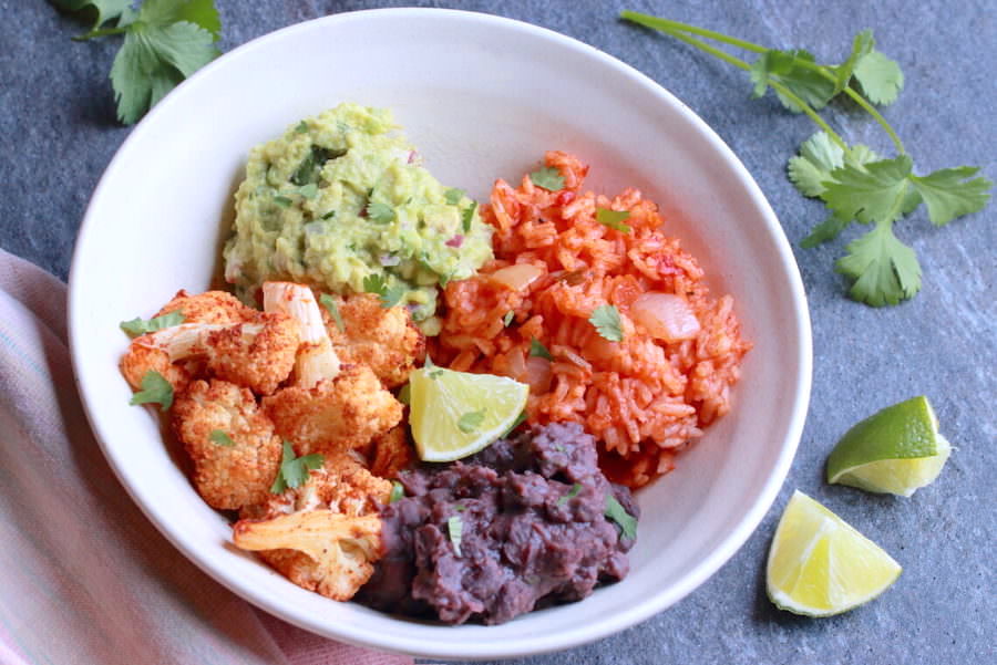 Cauliflower, guacamole, red rice, and black beans in a bowl