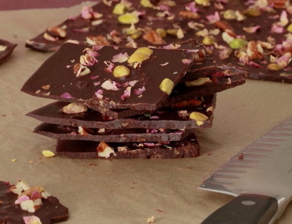 Stack of Dark Chocolate Bark with sheet of bark in rear