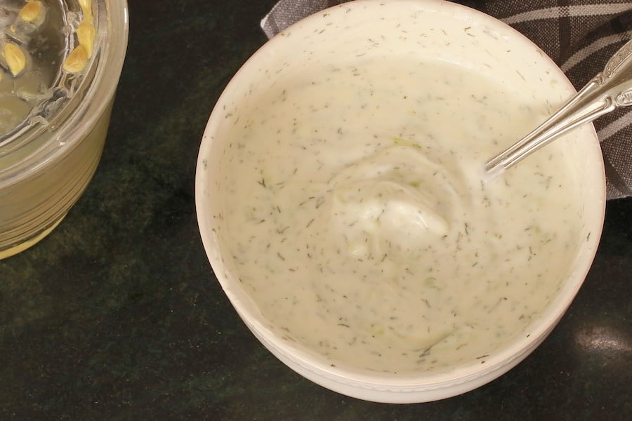Tzatziki Sauce in a bowl with a glimpse of lemon squeezer and napkin in the background