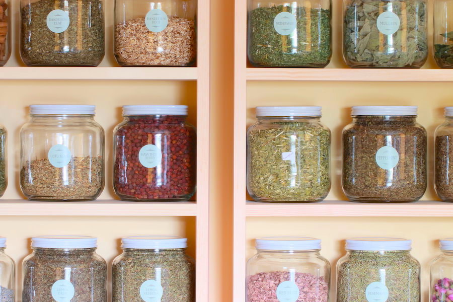 Close up of dry herbs arranged in glass jars