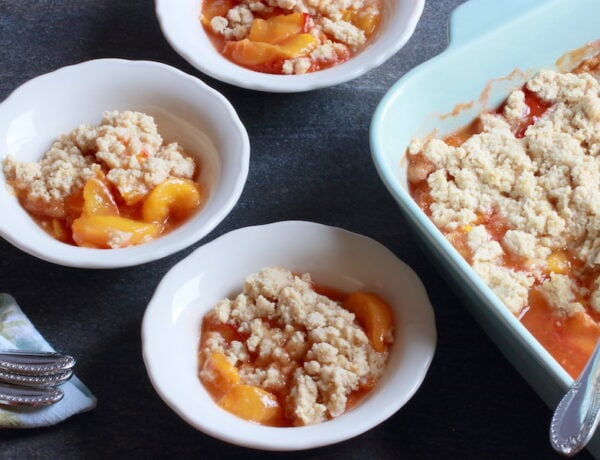 Vegan Peach Cobbler in baking dish. and in three small bowls