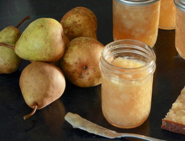 Half pint jars of pear jam; whole pears arranged to side