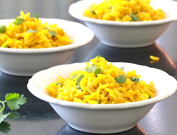 Three small bowls of rice with turmeric garnished with cilantro